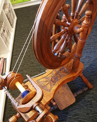 Spinning wheel made by Tom Jones with decorative carving of oak leaves